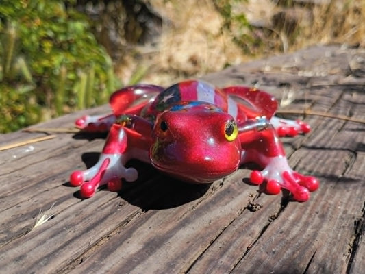 resin frog in wooded background
