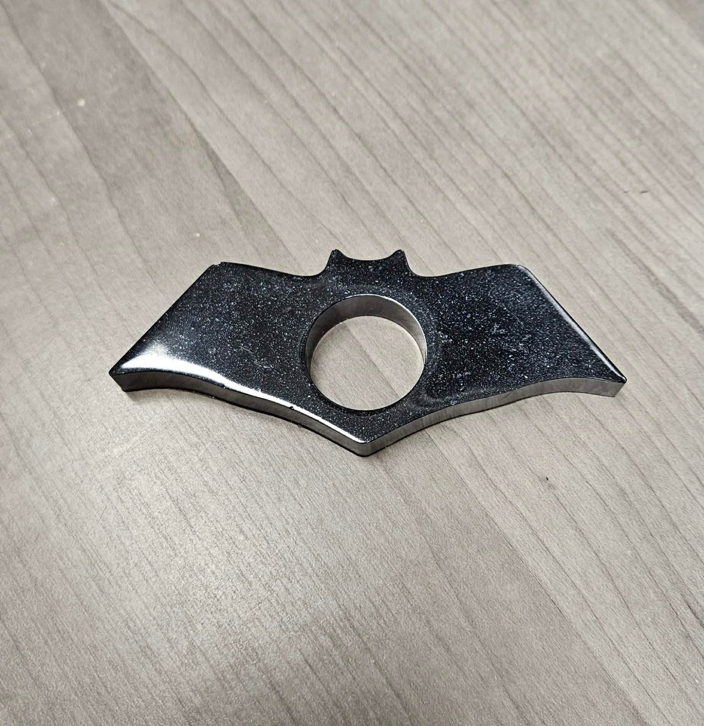 Bat-shaped page holder on a wooden surface