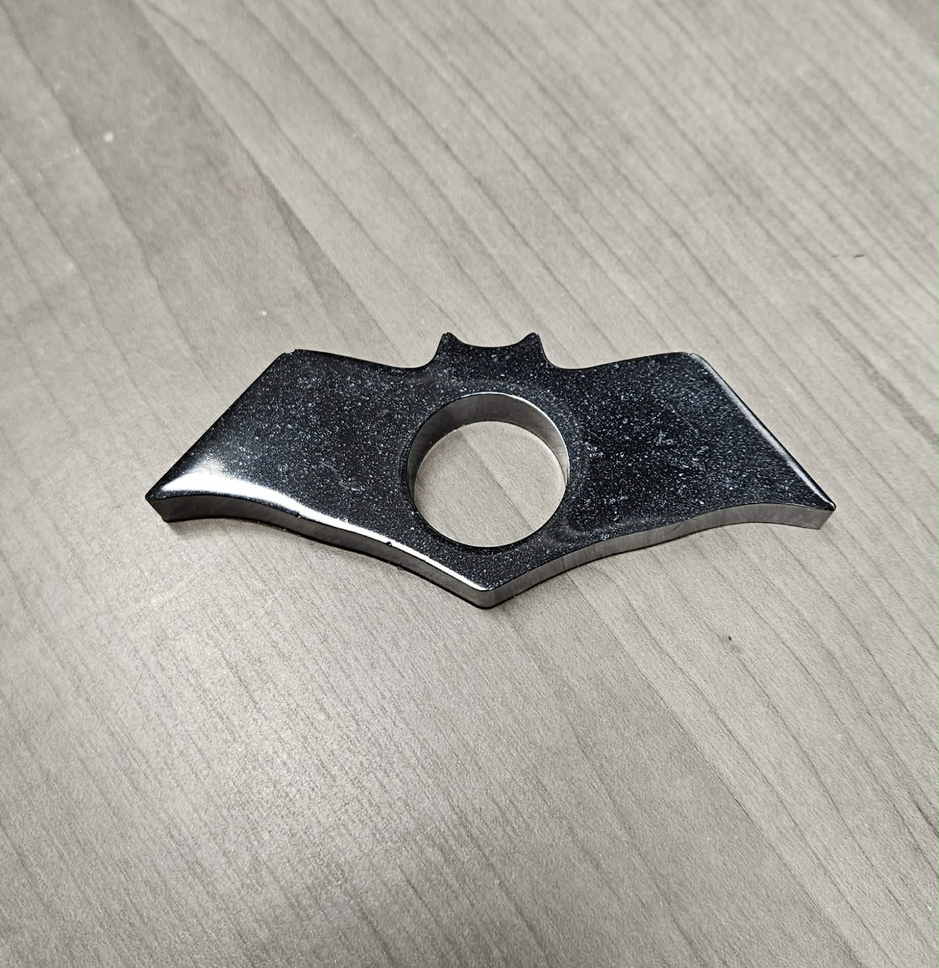 Bat-shaped page holder on a wooden surface
