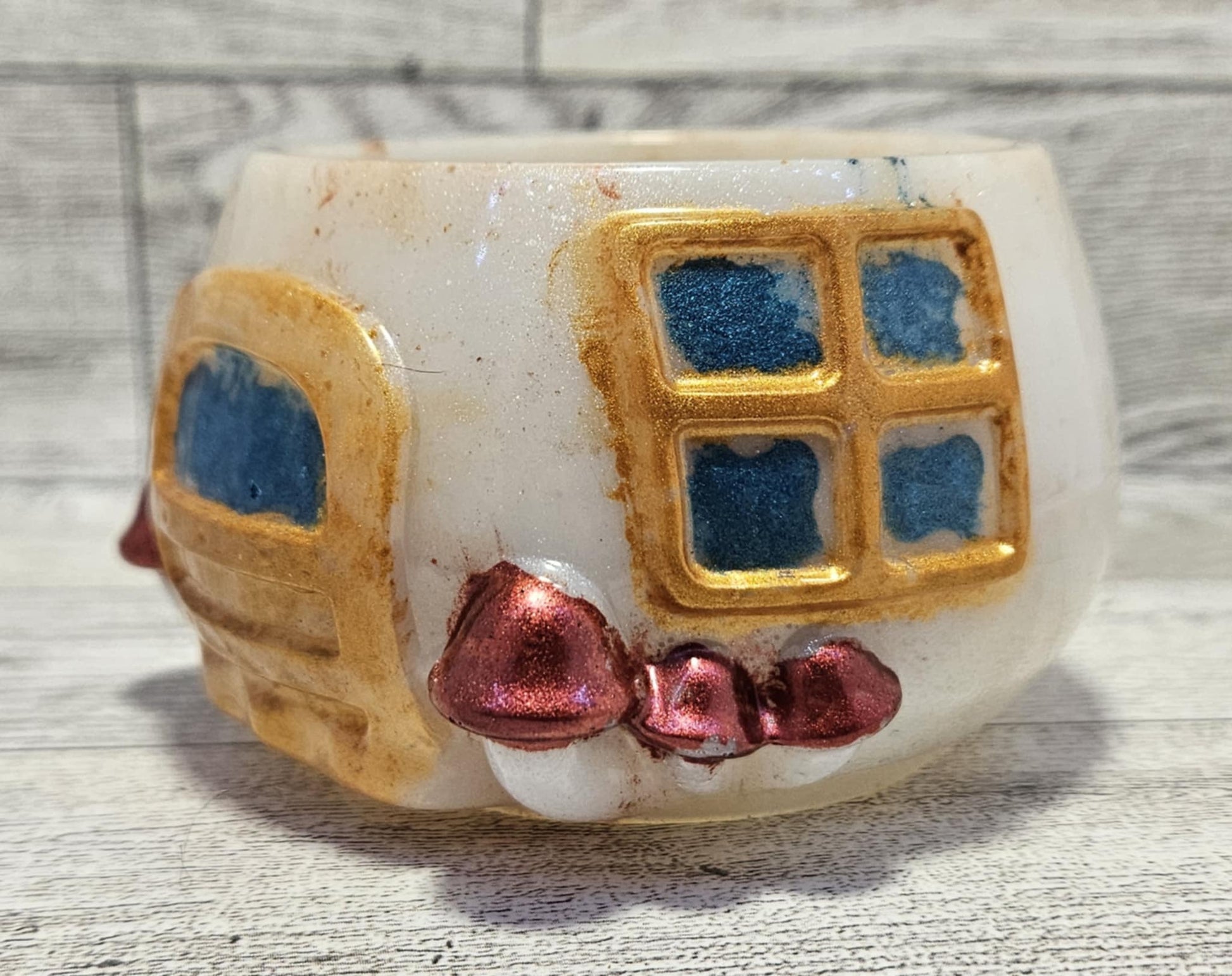 Resin Mushroom base, on wood surface, showing gold door and window, small mushrooms on the side of door.