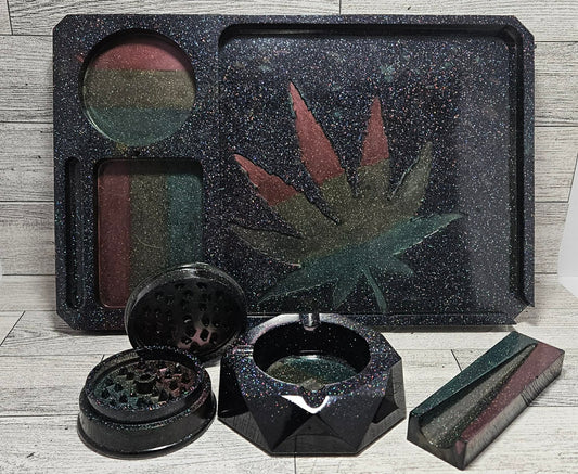 Set of black smoking accessories with a cannabis leaf design on a wooden surface