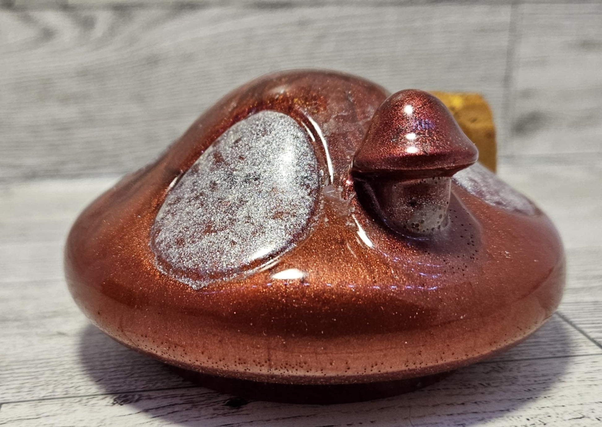 Resin mushroom jar top with a textured surface on a wooden background