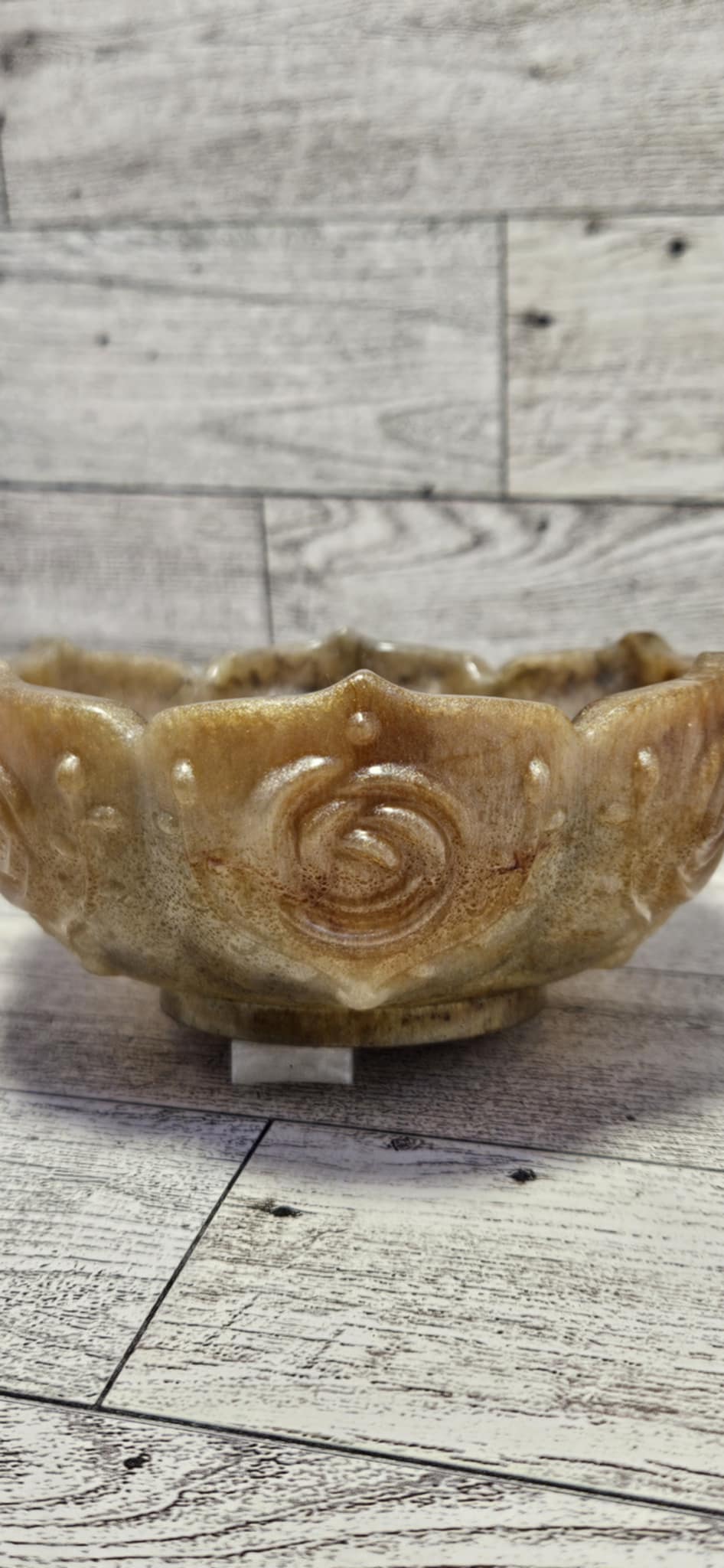 Decorative ceramic bowl with rose design on a wooden surface