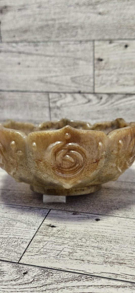 Decorative ceramic bowl with rose design on a wooden surface