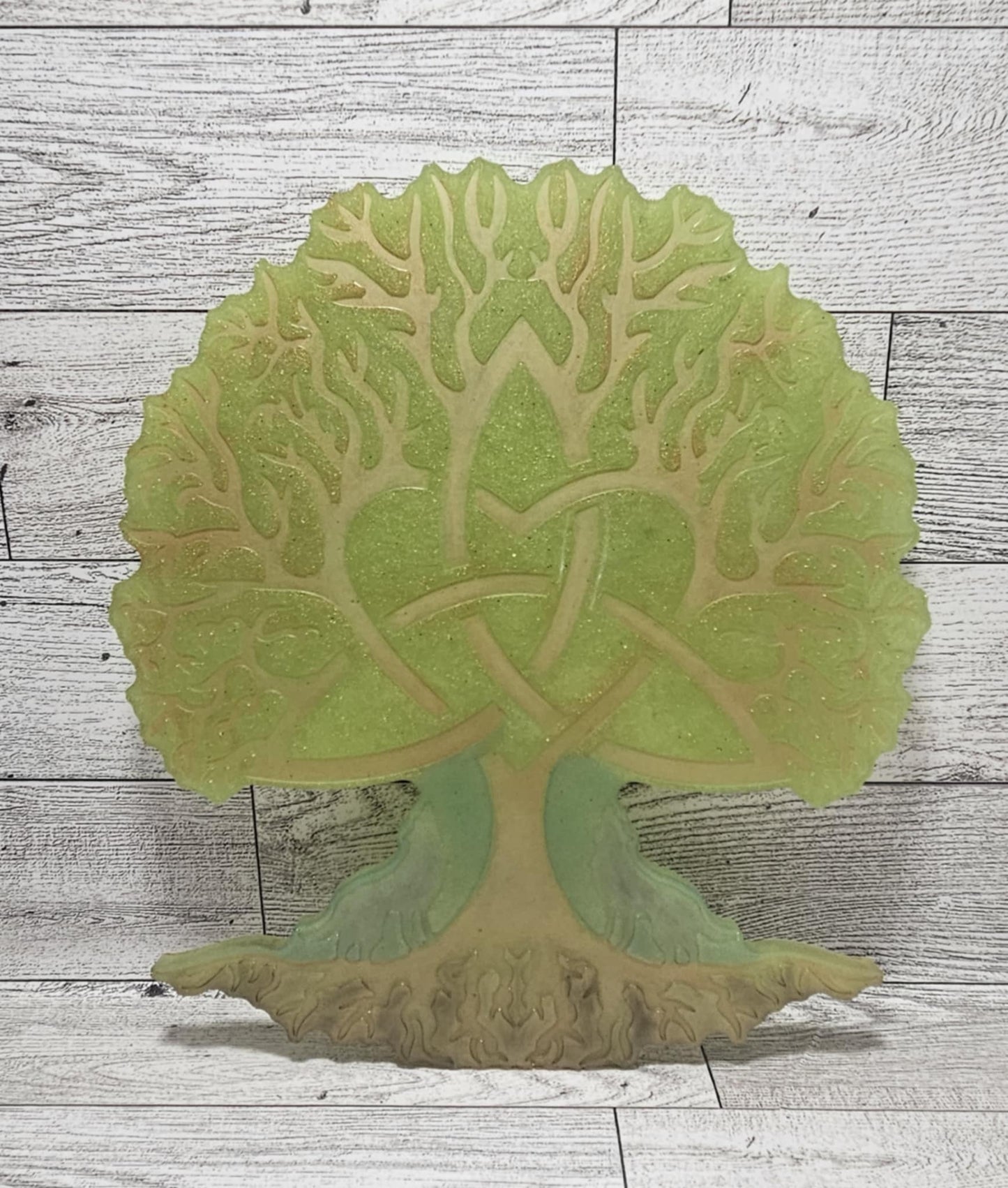 Decorative wall art of a tree with intricate details on a wooden surface