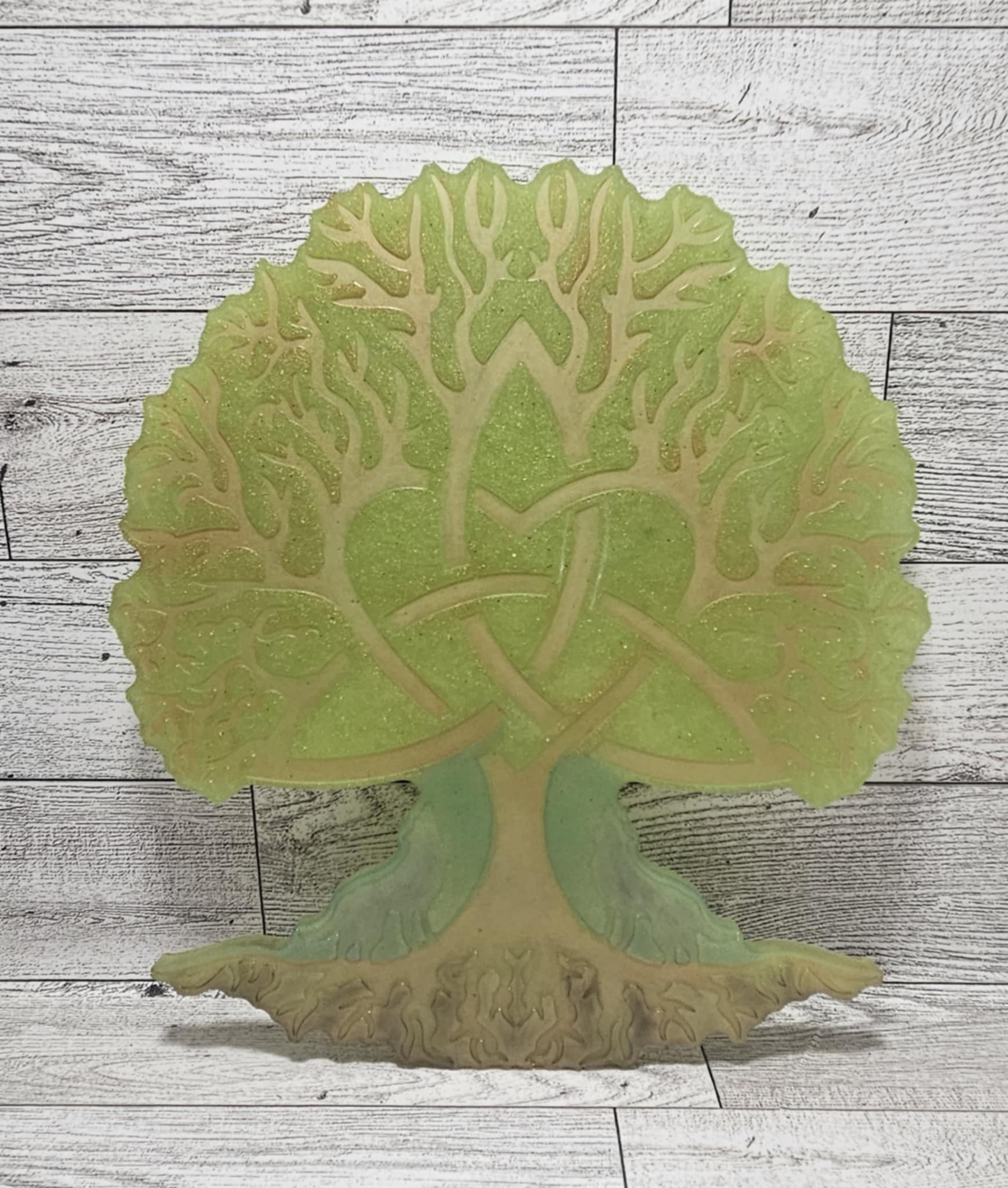 Decorative wall art of a tree with intricate details on a wooden surface