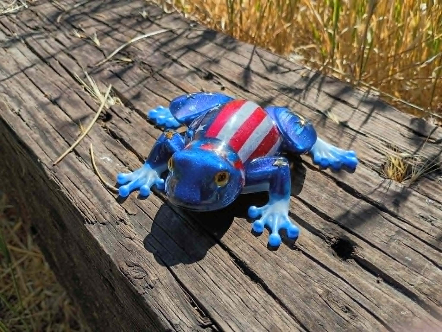 resin frog in wooded background