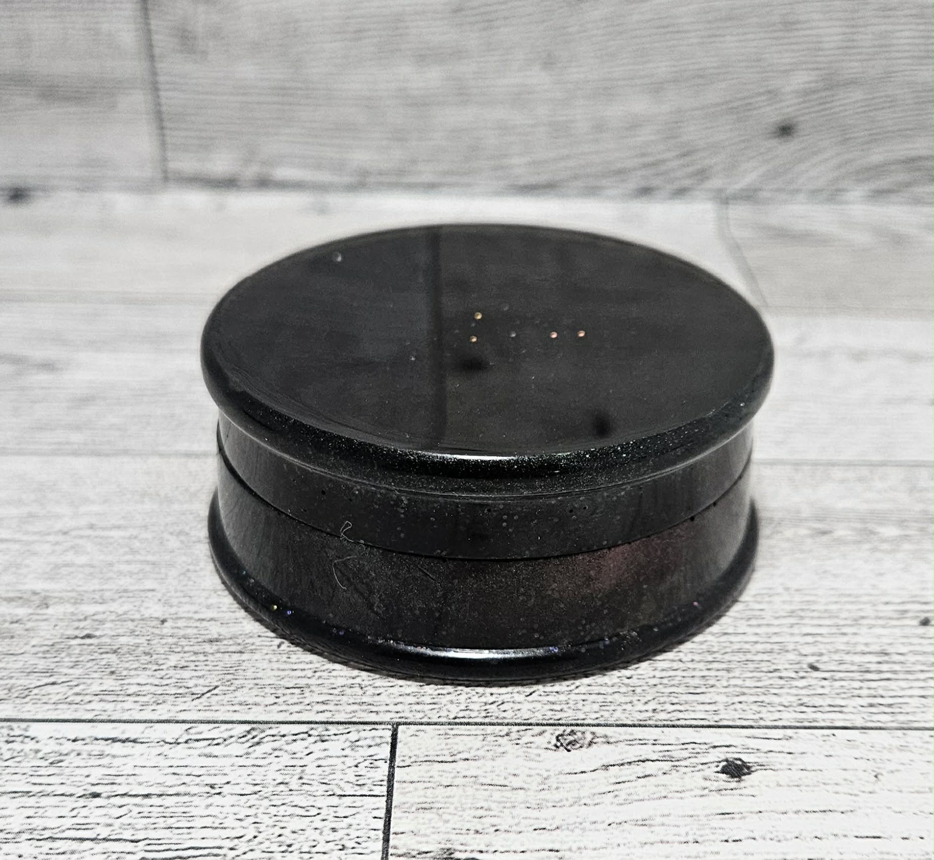 Black circular object on a wooden surface