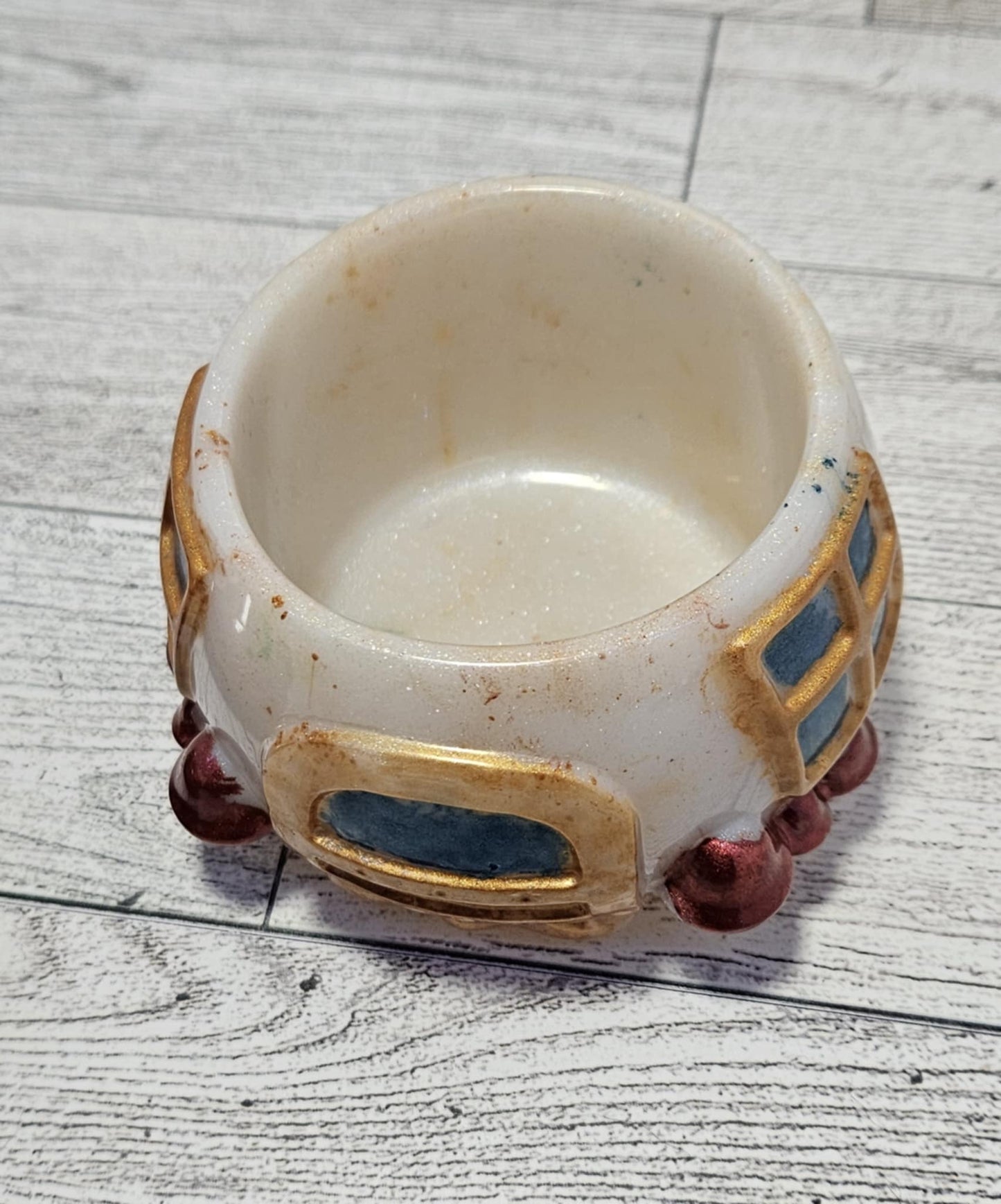 Resin mushroom jar with decorative elements on a gray wood surface.