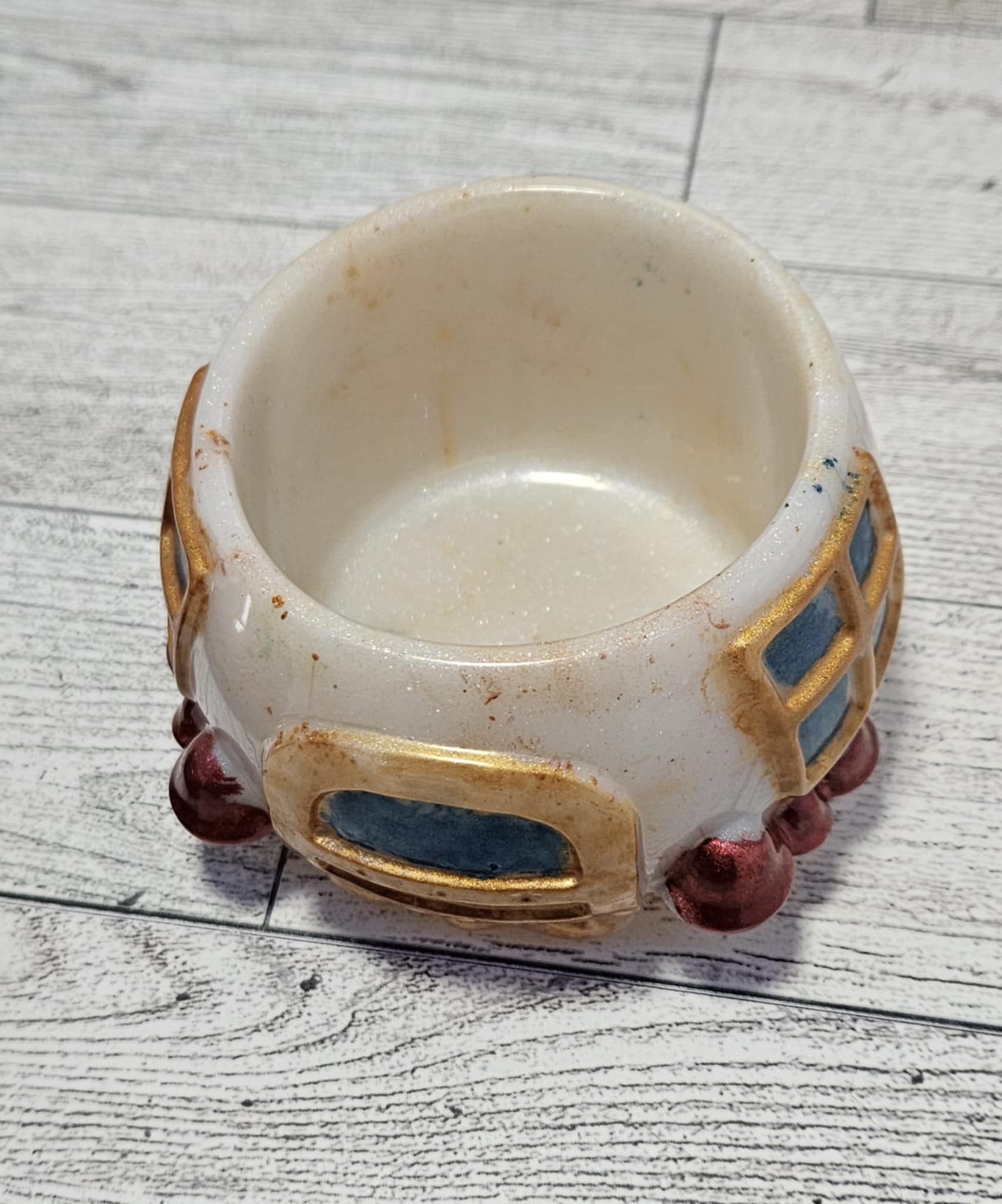 Resin mushroom jar with decorative elements on a gray wood surface.