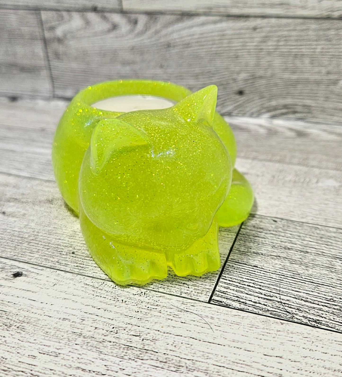 Green cat-shaped candle holder on a wooden surface