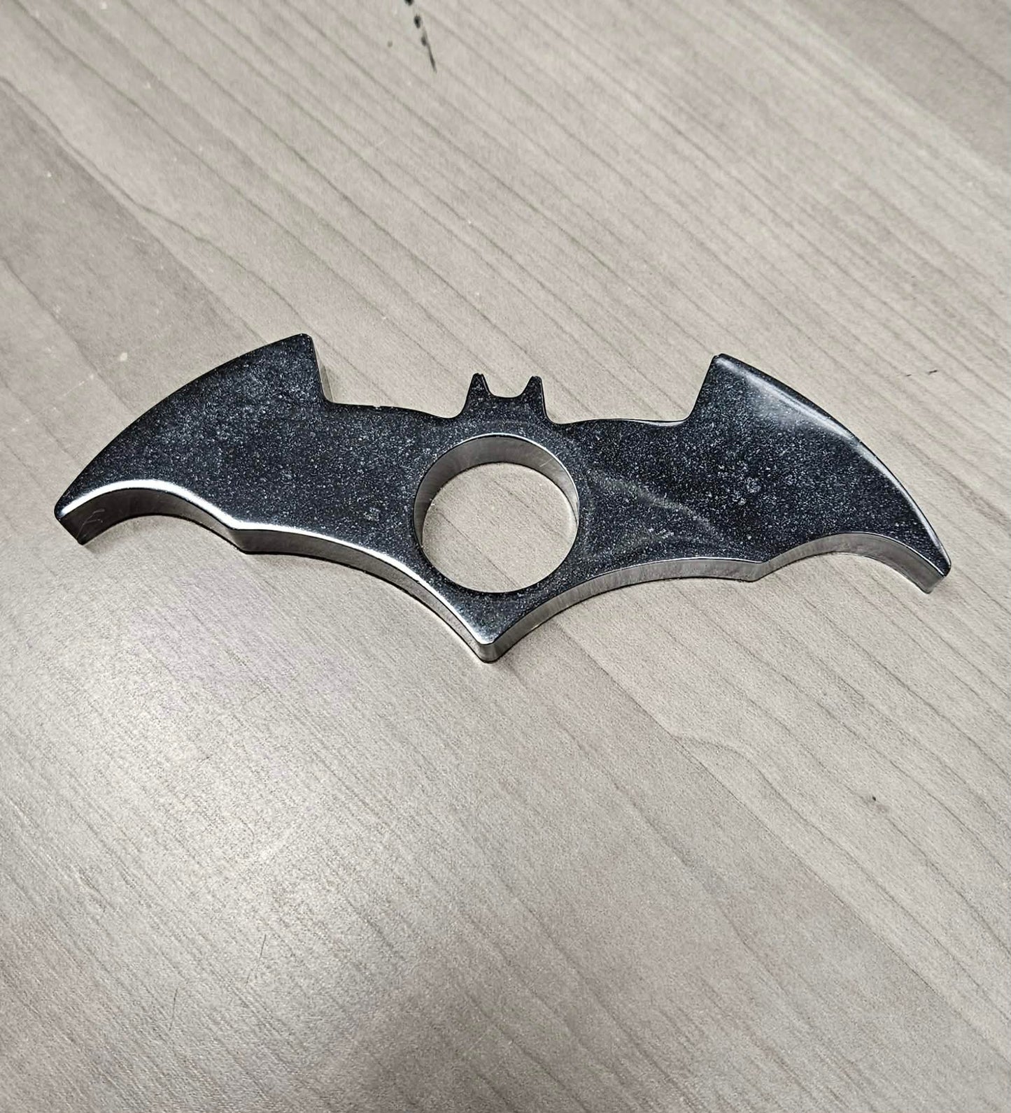 Bat-shaped page holder on a textured gray surface