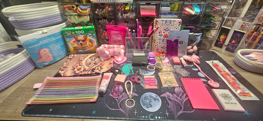 Collection of stationery items on a table with a focus on colorful pouches and small accessories.