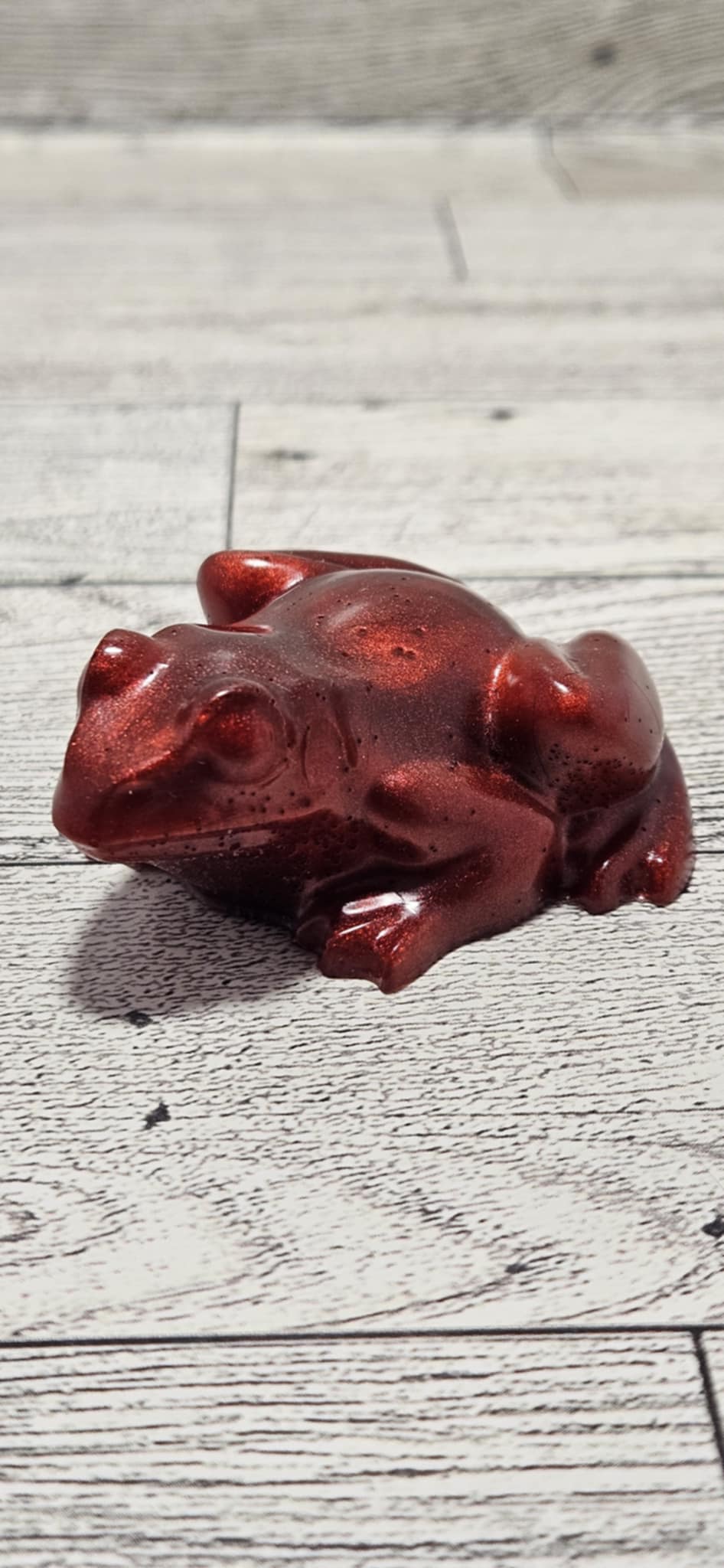 Red frog figurine on a wooden surface