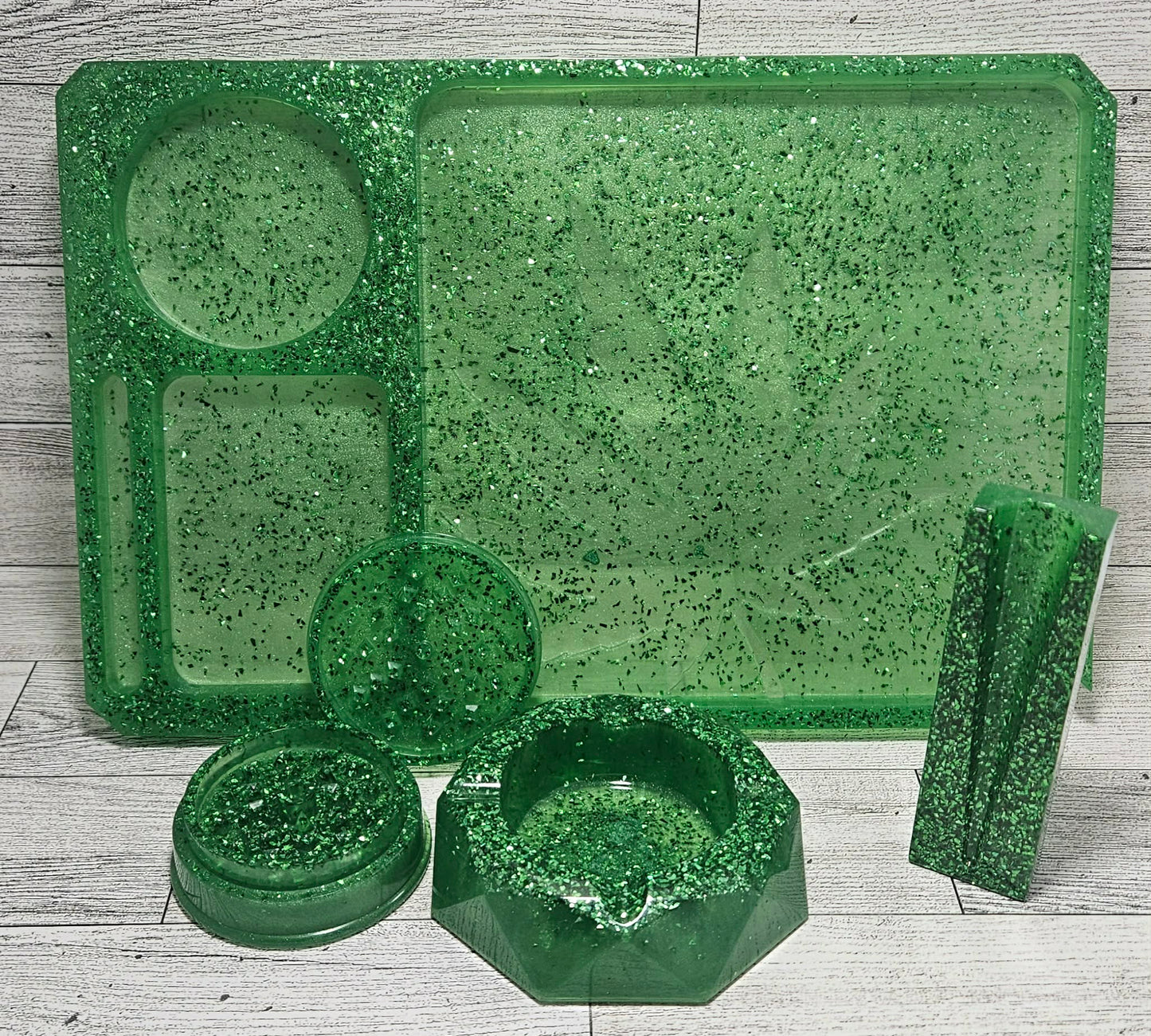 Green speckled plastic trays and containers on a wooden surface
