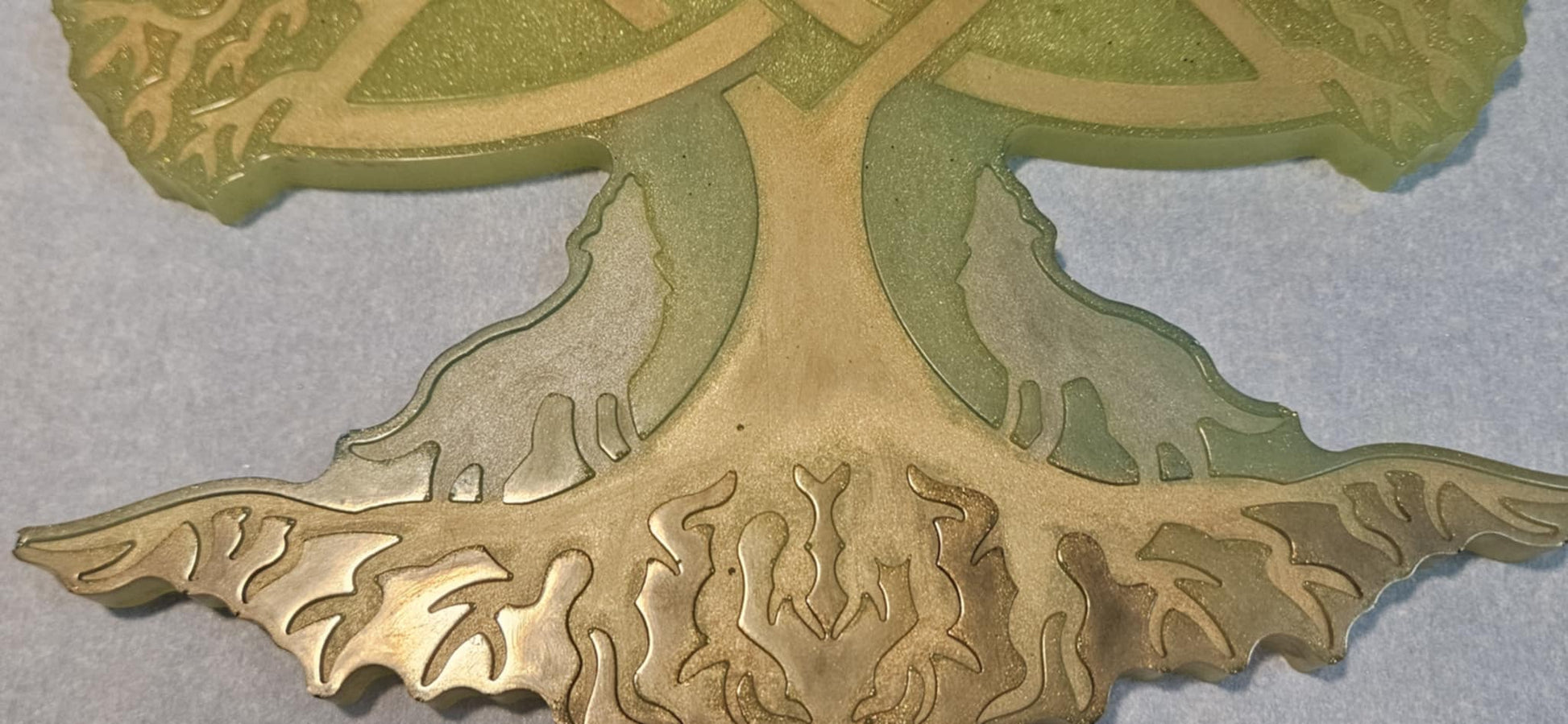 Decorative wall art of a tree with Celtic knot design closeup on light blue surface