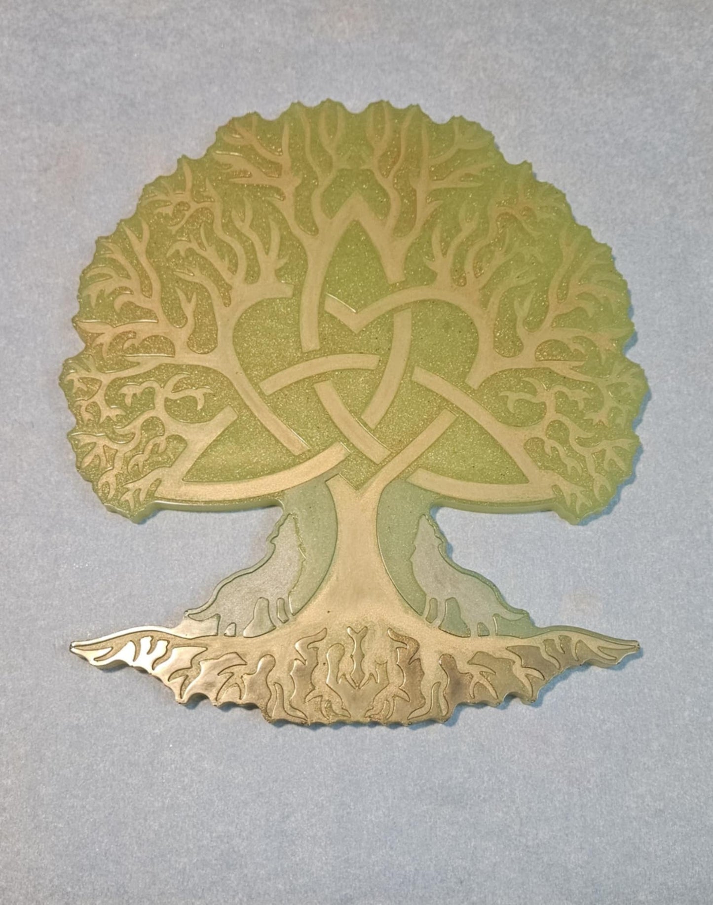 Decorative wall art of a tree with Celtic knot design on a light blue surface
