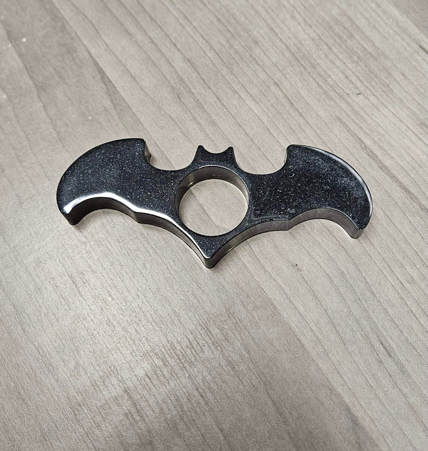Bat-shaped book page holder on a wooden surface