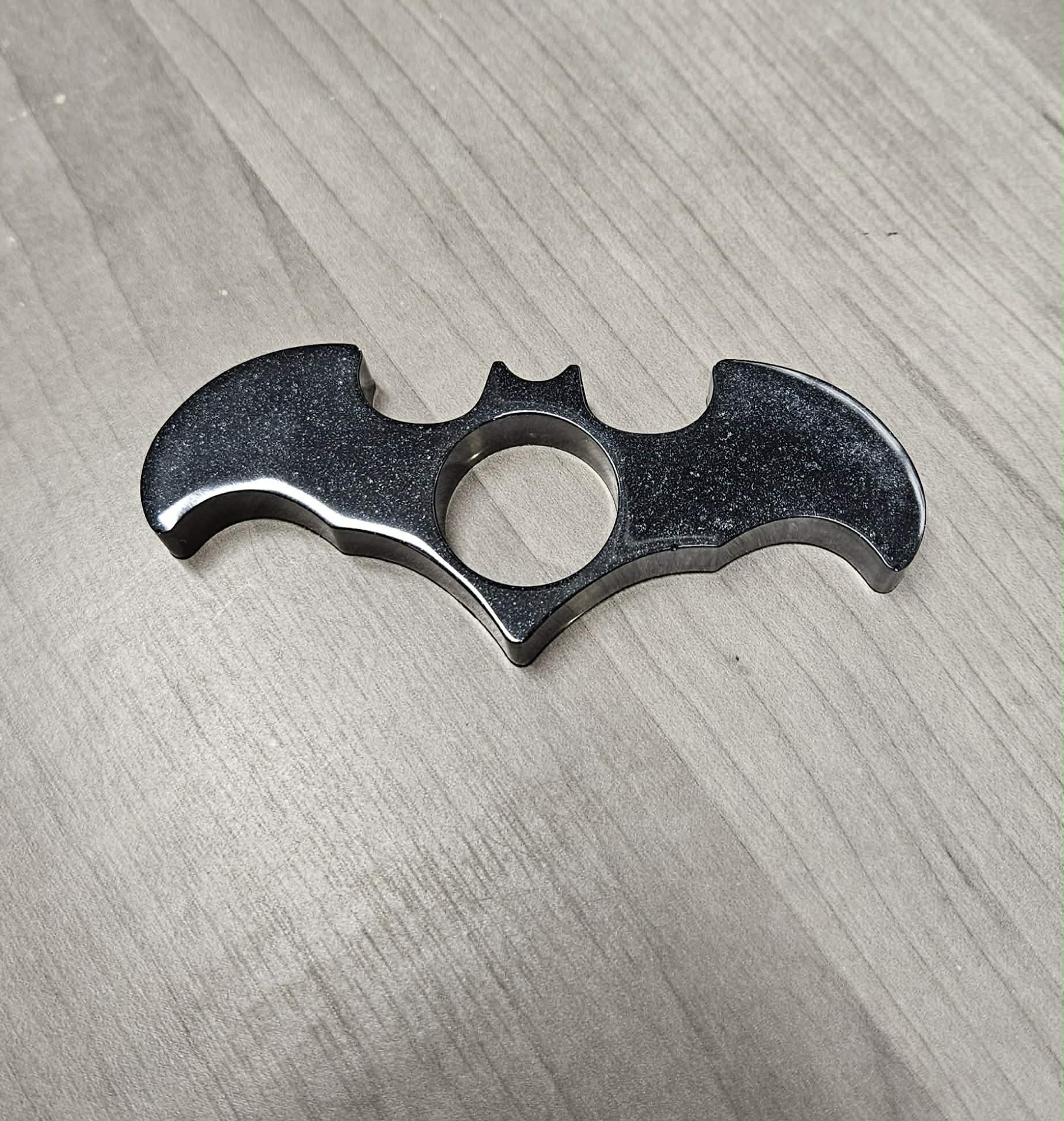 Bat-shaped book page holder on a wooden surface